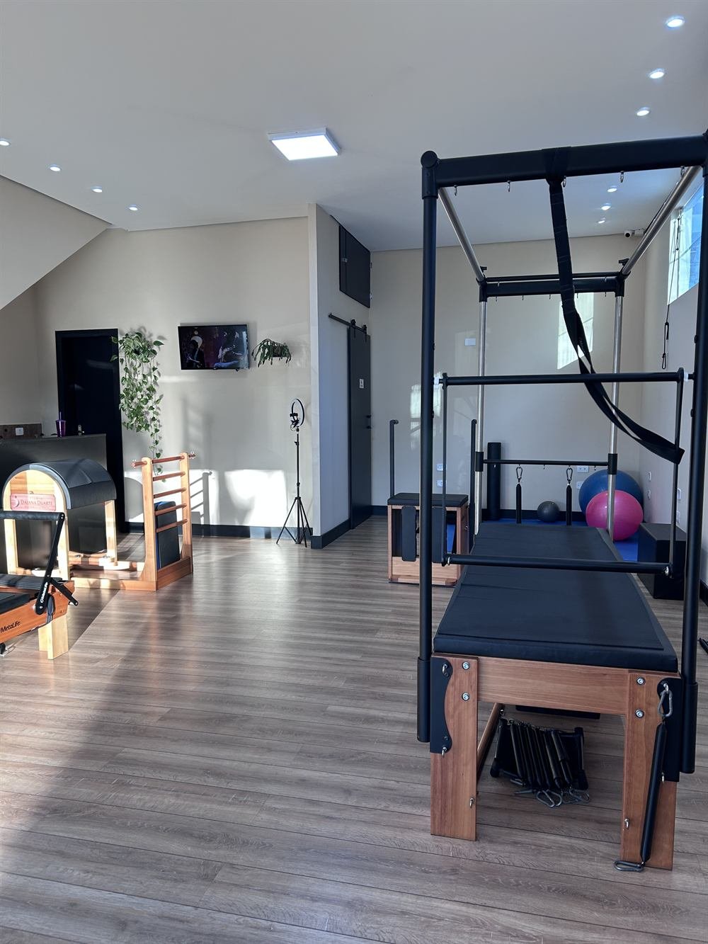 Sala ampla e organizada do Studio Daiana Duarte, com Cadillac e aparelhos de Pilates