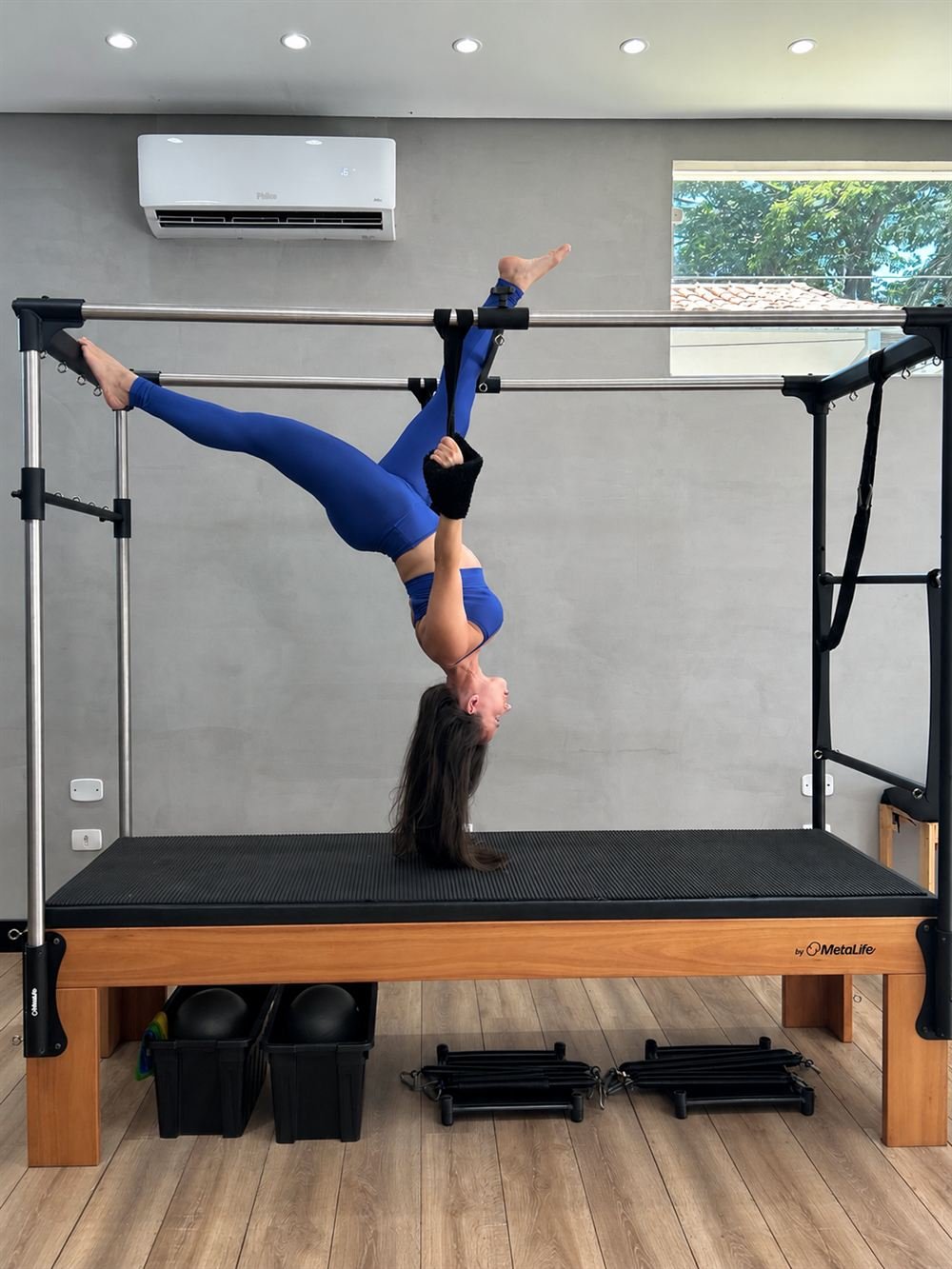 Aluna em exercício invertido no Cadillac, com acompanhamento no Studio Daiana Duarte